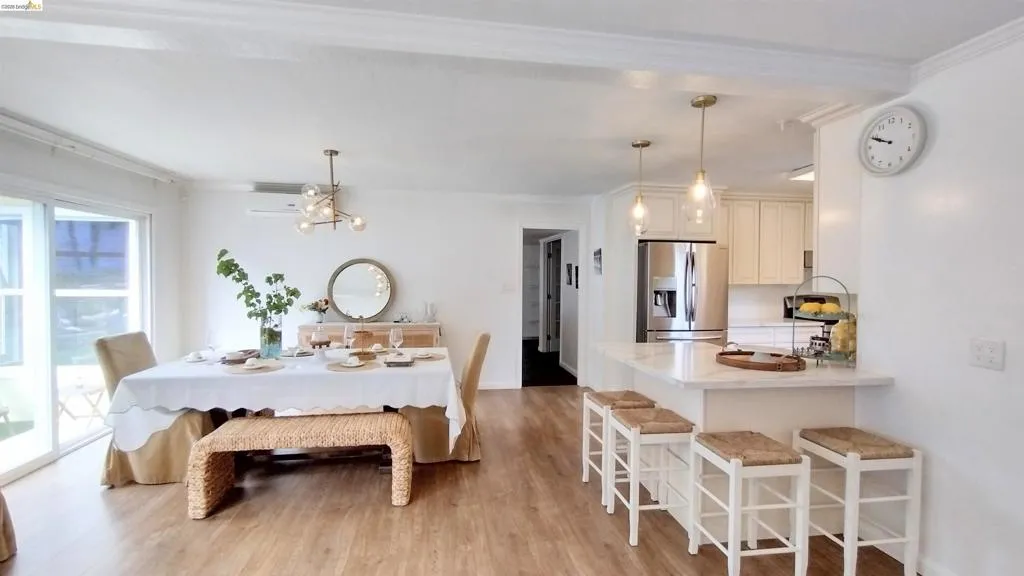 Dining space featuring light wood-style flooring, ornamental molding, and a chandelier