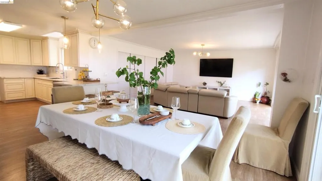 Dining area with a chandelier, light wood finished floors, and ornamental molding