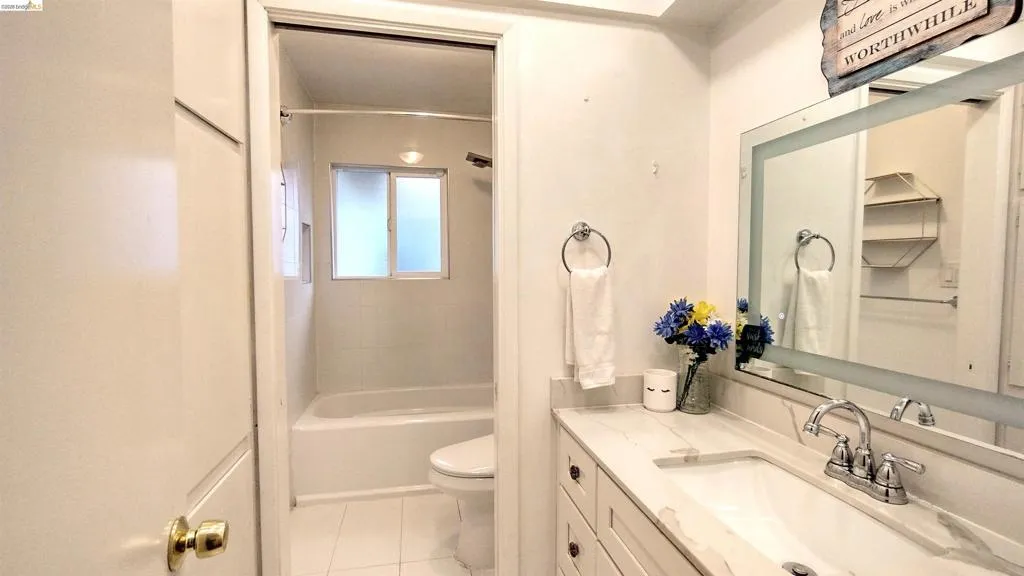 Bathroom featuring vanity, shower / washtub combination, and light tile patterned floors