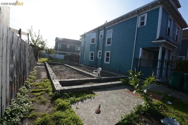 Back of house featuring a fenced backyard and a vegetable garden