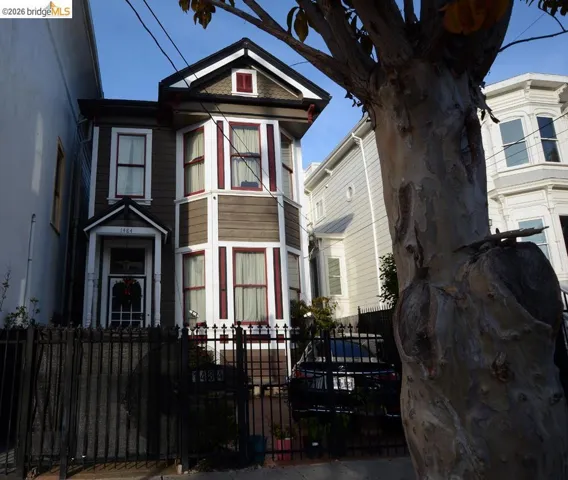 Victorian house featuring a fenced front yard and a gate