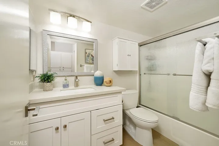 Bathroom with soft-close, white Shaker cabinets and quartz countertops; full bath with shower and tub