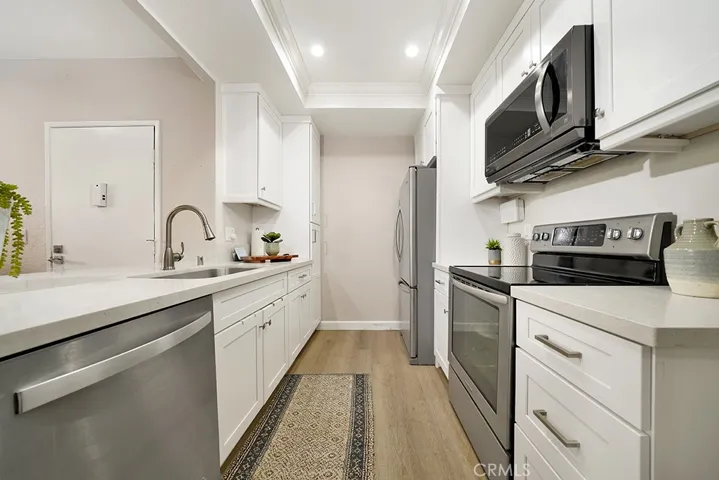 Kitchen with quartz countertops, soft-close, white Shaker cabinets and stainless steel appliances