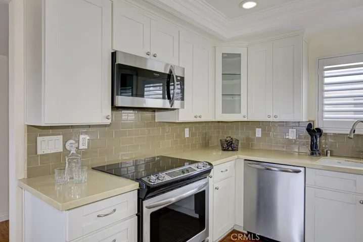 Here's the other side of the kitchen with more cabinets and counters. There's even a pretty glass front corner cabinet.