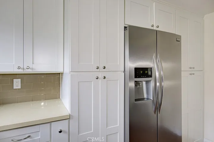 The glass tile backsplash accents the quartz counters.