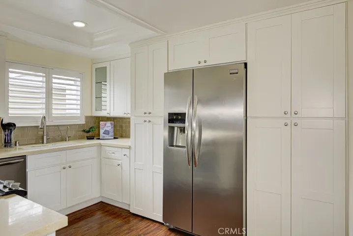 The custom kitchen has been outfitted with lots of cabinets, a full size refrigerator, plantation shutters, dishwasher and freestanding range and oven.