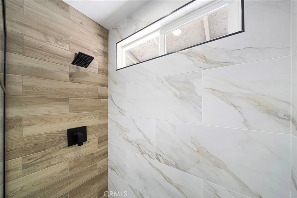 Nice accent of color and style in the primary en suite walk in shower. Double pane window overlooks the backyard.