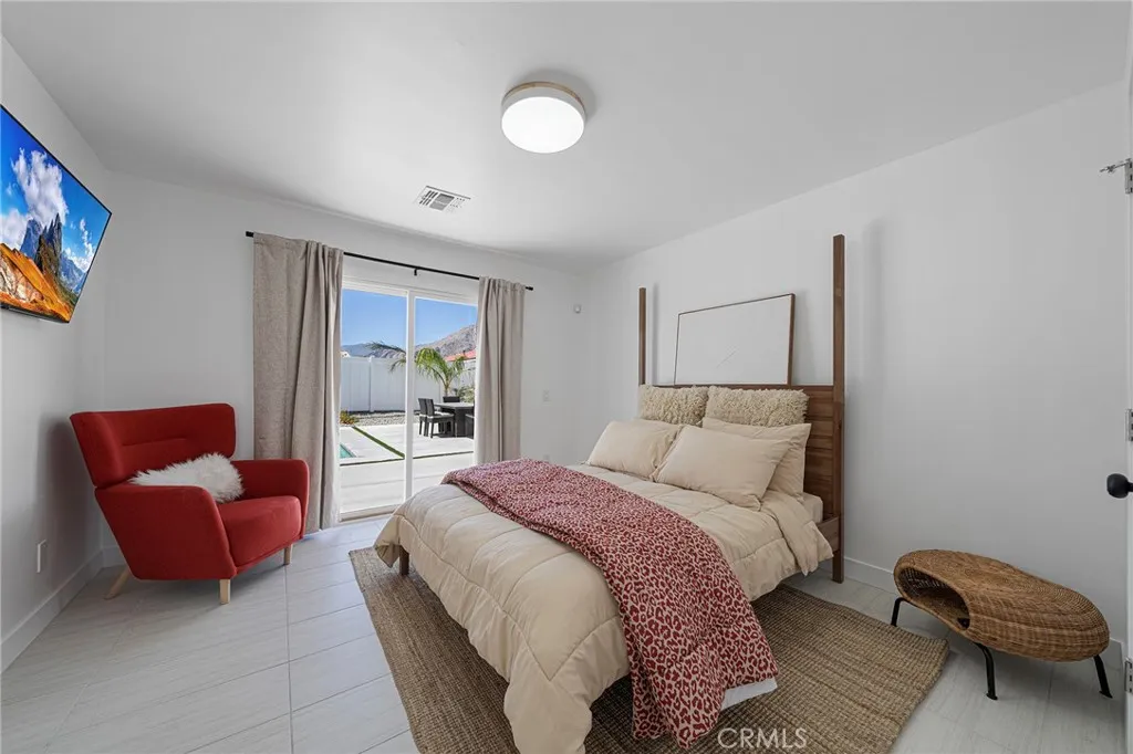 Primary bedroom with private en suite has a double pane slider to the backyard. Furniture remains.