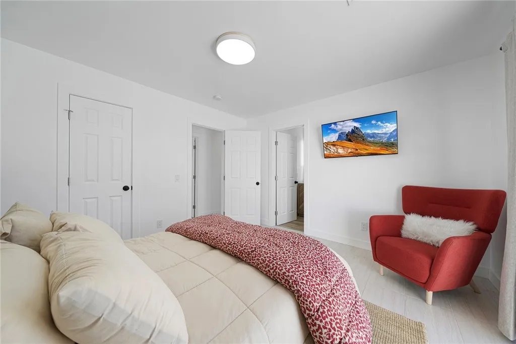 Primary bedroom with private en suite has a double pane slider to the backyard. Furniture remains.