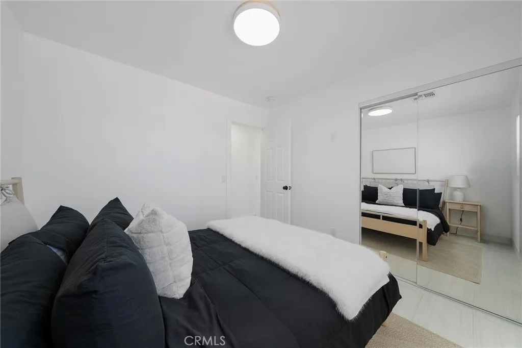 This bedroom is first one on the right going down the hallway right from the entry. Tile flooring, double pane window, mirrored closet doors and view of the front yard. Furniture remains.
