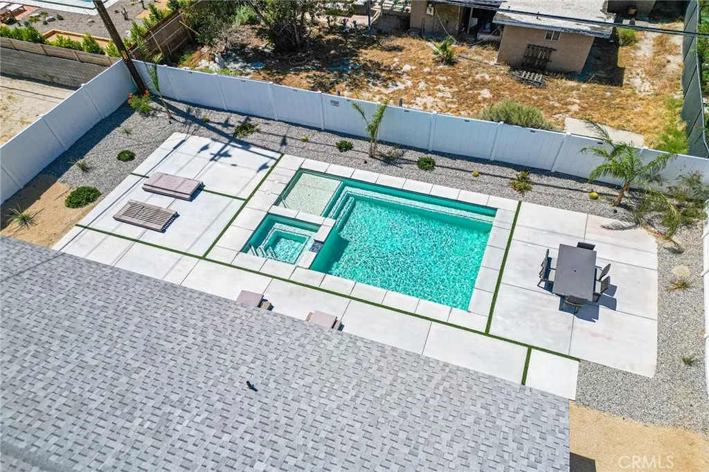 Roof view looking at the concrete/turf patio adn pool with Baja shelf. Plenty of space for entertainment.