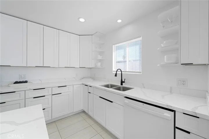 Clean and updated kitchen with appliances to remain and items in cabinets remain as well. Having a clean white palate allows you to bring your color choice of decor and dishes as desired. Window view of spacious side yard.