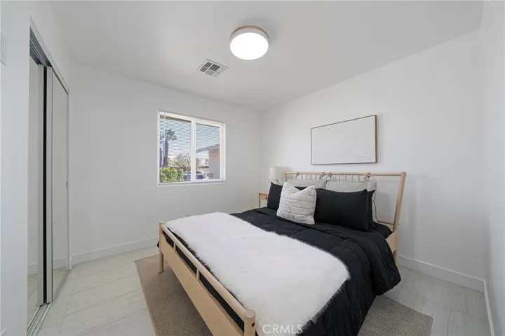 This bedroom is first one on the right going down the hallway right from the entry. Tile flooring, double pane window, mirrored closet doors and view of the front yard. Furniture remains.