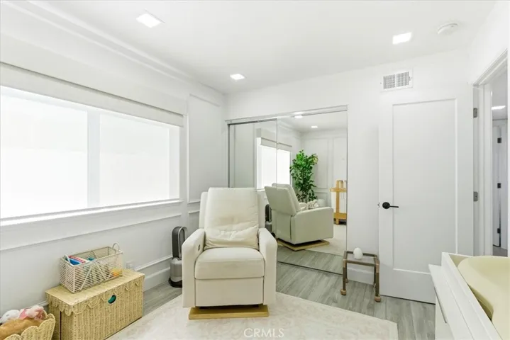 Corner view of the same nursery/sitting area, highlighting the window and seating arrangement.