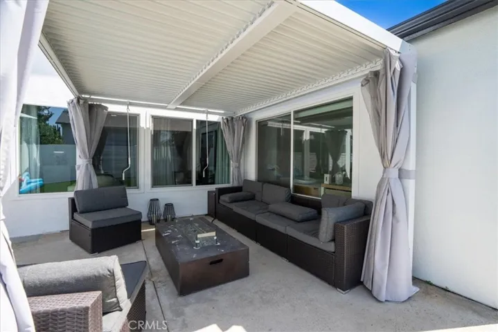 Covered outdoor patio with seating area, ideal for relaxing or entertaining.