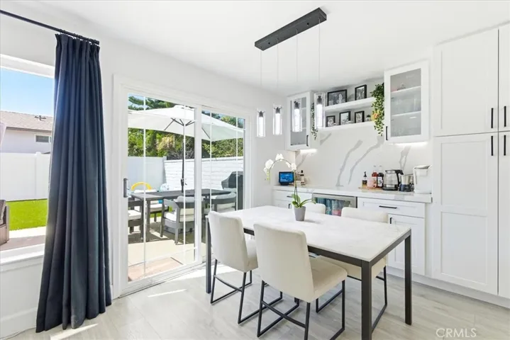 Bright dining area with marble table, pendant lighting, and sliding doors to the backyard.