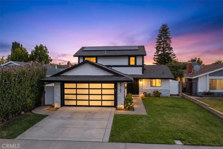 Front view of a modern two-story home with a two-car garage, clean driveway, and well-maintained lawn.