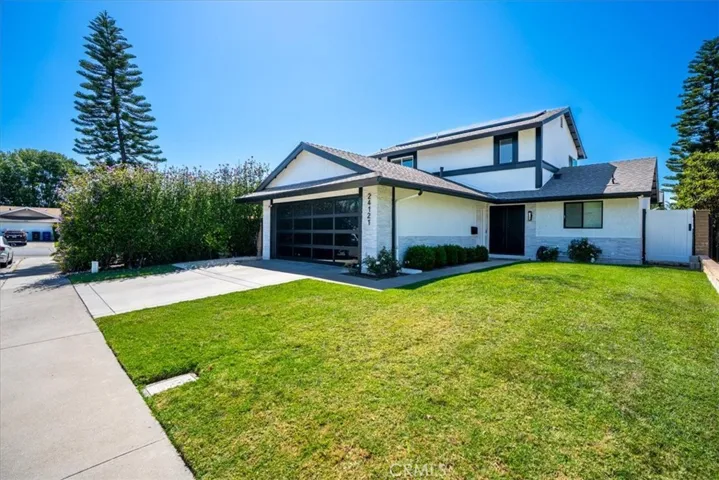 Front view of a two-story home from a left-angle perspective, highlighting the two-car garage and landscaped lawn.