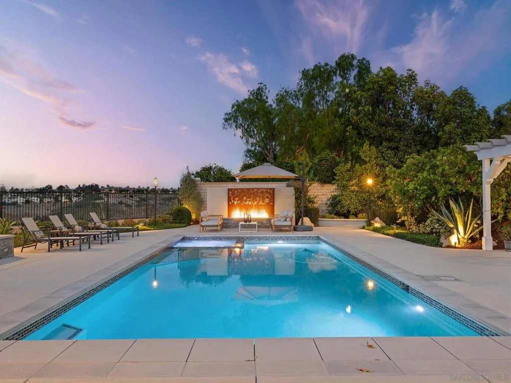Massive Pebbletec pool with integrated spa with a great electric solar pool cover, along with the art and fire feature!