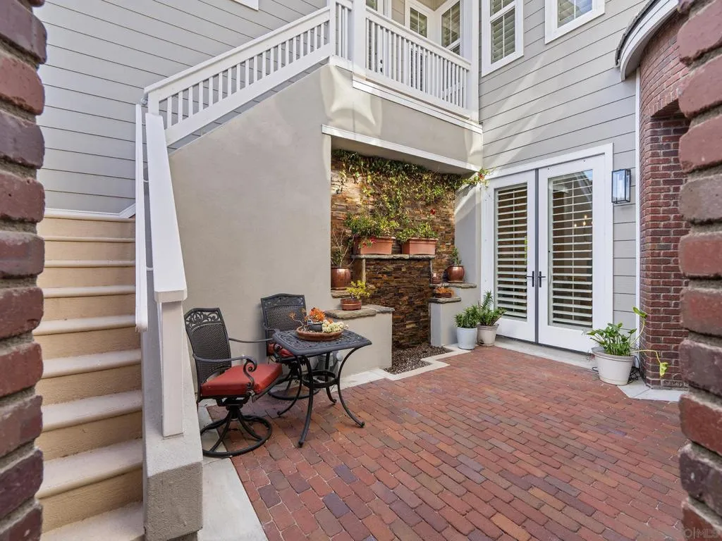 Wonderful  sunny courtyard entry with water feature sitting area, and staircase up to guest suite
