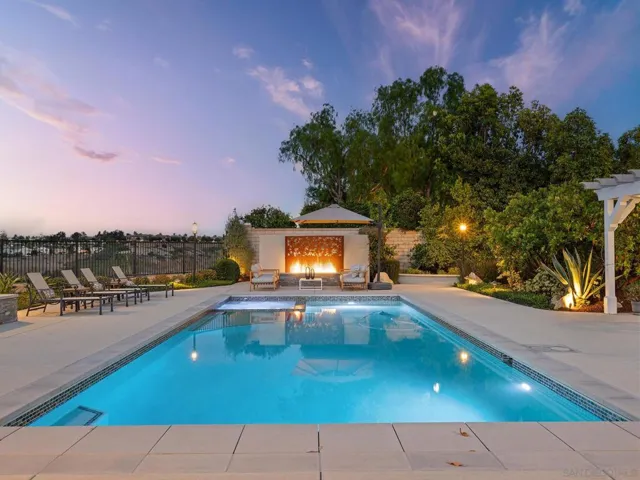Massive Pebbletec pool with integrated spa with a great electric solar pool cover, along with the art and fire feature!