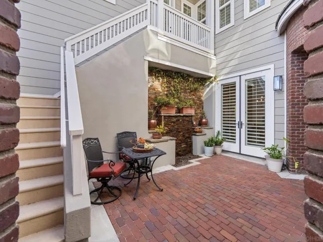 Wonderful  sunny courtyard entry with water feature sitting area, and staircase up to guest suite