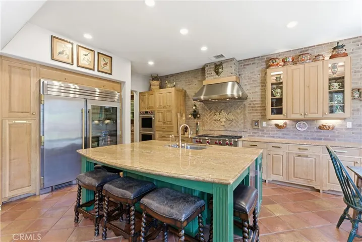 Thoughtfully designed for both function and style, the kitchen showcases extensive cabinetry, custom finishes, and high-end appliances throughout.