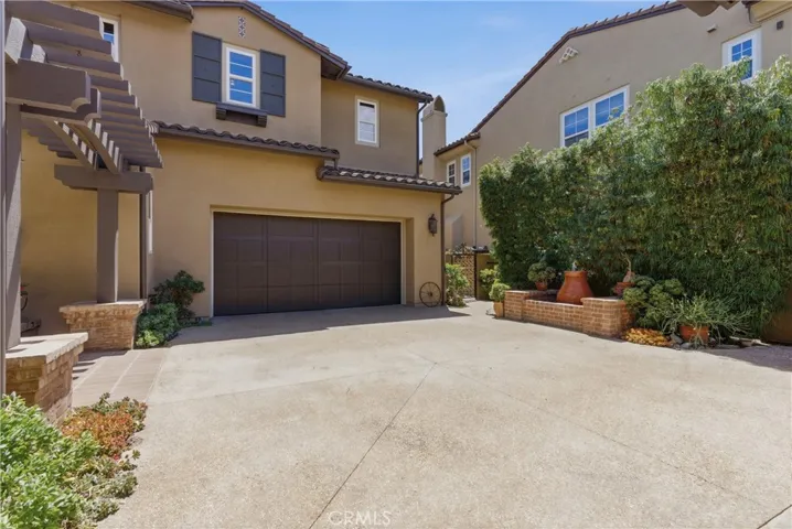 The spacious garage courtyard offers ample guest parking and convenient access to the oversized garage, all surrounded by mature landscaping and timeless architectural details.