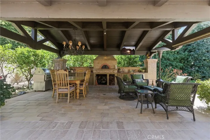Designed for year-round entertaining, this impressive covered pavilion includes a wood-fired Mugnaini pizza oven, barbecue, prep space, and multiple gathering areas.