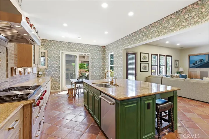 The kitchen opens to a charming breakfast area with direct access to outdoor entertaining spaces, creating a seamless indoor-outdoor lifestyle.