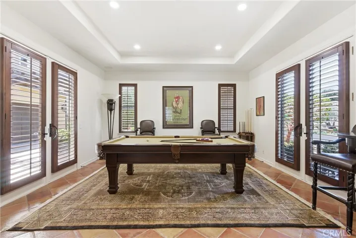 A versatile game room with French doors, plantation shutters, recessed lighting, and abundant natural light offers the perfect space for recreation or entertaining.