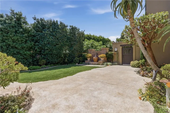 Beautifully landscaped grounds with decorative fountain, expansive patio space, and garden-inspired surroundings.