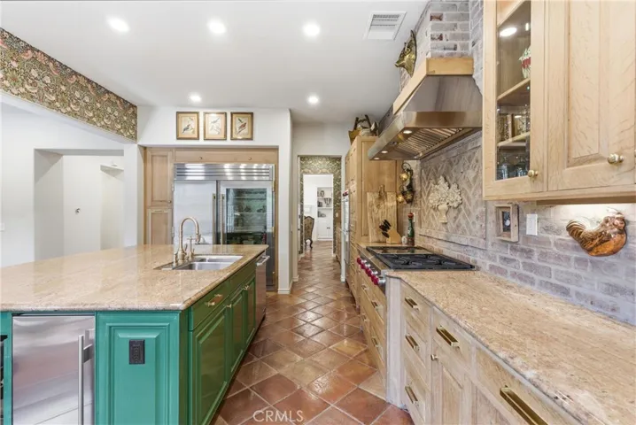 The expansive island with prep sink is complemented by extensive cabinetry, premium appliances, and timeless architectural character.
