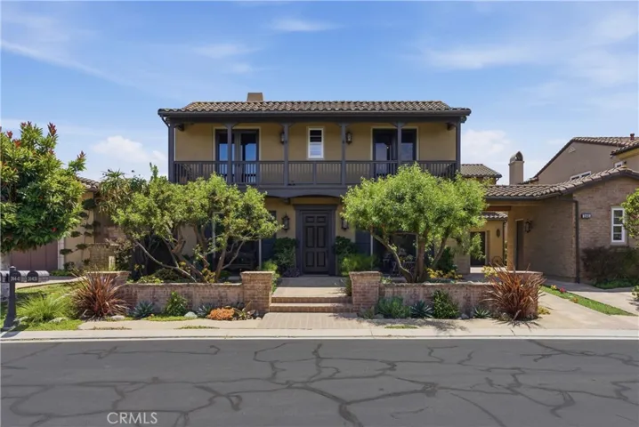 A welcoming façade highlighted by a spacious second-story veranda, manicured grounds, and a charming courtyard-style approach that sets the tone for the home's timeless character.