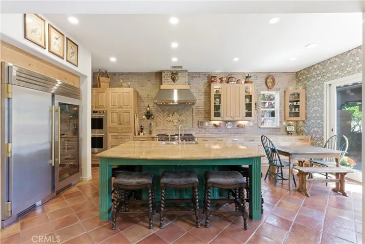 A generous center island anchors the kitchen, providing additional seating, prep space, and an ideal gathering place for family and guests.
