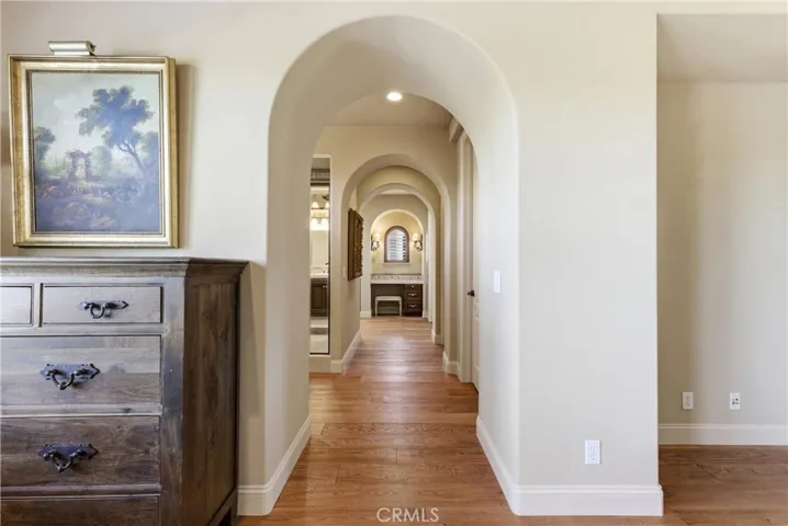 Elegant arched passageways lead from the primary suite to the spa-inspired primary bathroom.