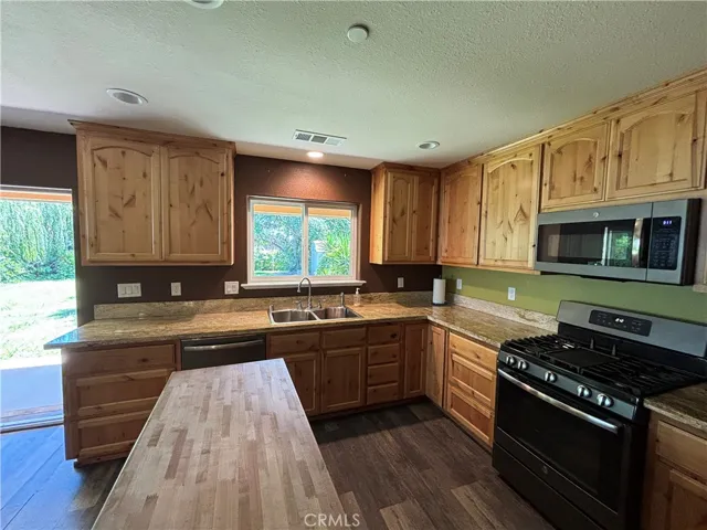 Kitchen with lovely views of back yard, rolling island and granite counters and beautiful cabinets