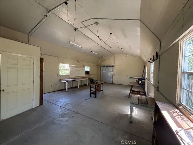 Workshop with work bench, high ceiling, and 2 roll up doors.