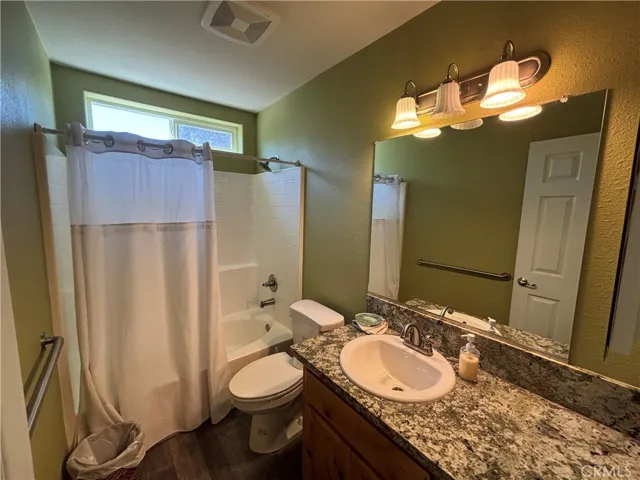 Guest bathroom with tub shower and granite counters