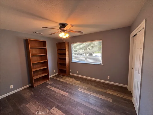 Guest bedrrom with shelves and ceiling fan