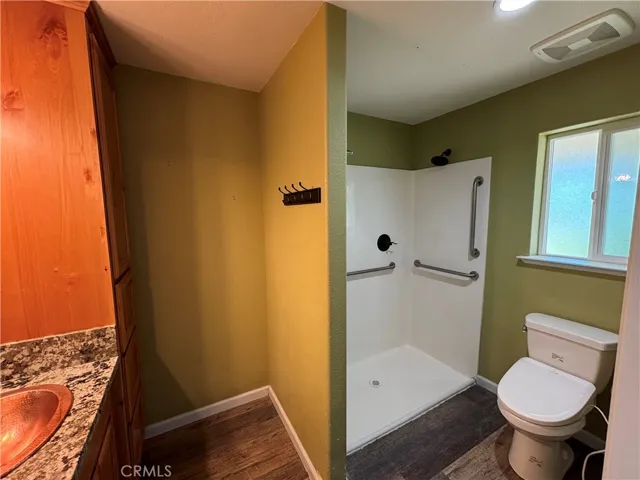 Primary bathroom with gorgeous granite counters, copper sink and walk in shower