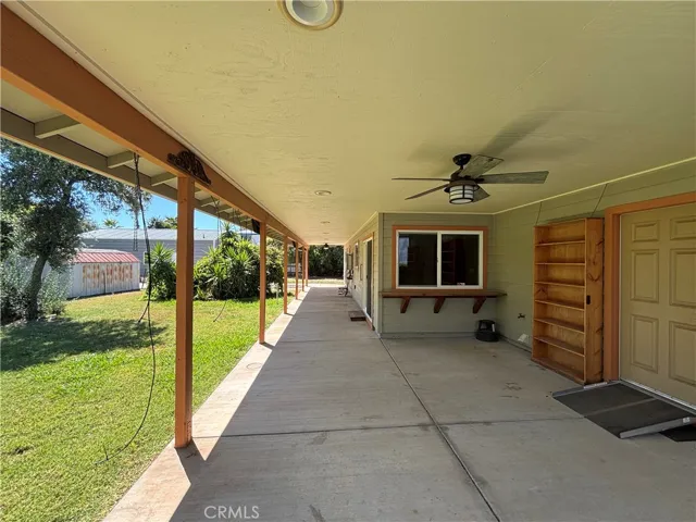 Covered pation with ceiling fan and access to garage, dining room and primary bedroom.