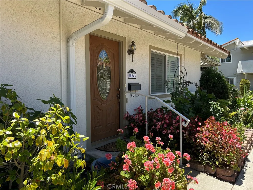 Inviting front door entry with vibrant flowers