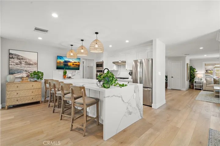 Quartz peninsula with waterfall and seating with pendant lights