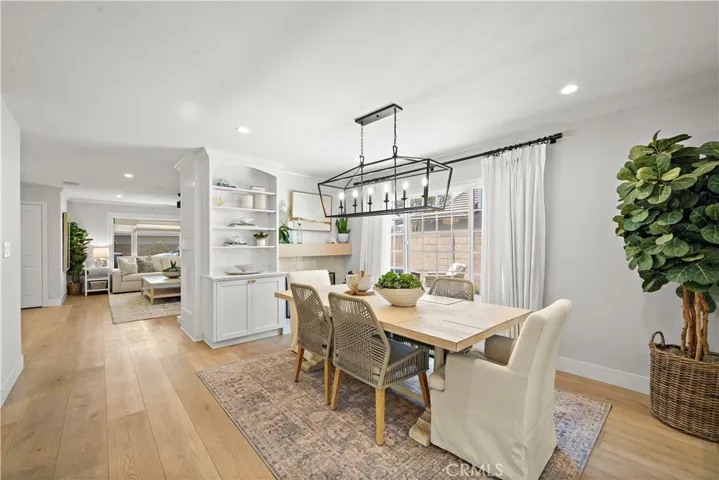 Dining room with fireplace and custom built-ins flows seamlessly into the formal living room