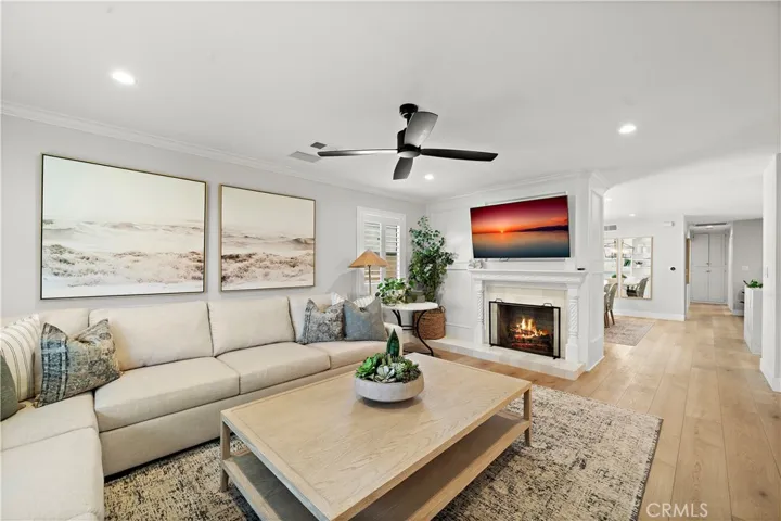 Formal living room with fireplace flows into dining room, family room, and kitchen
