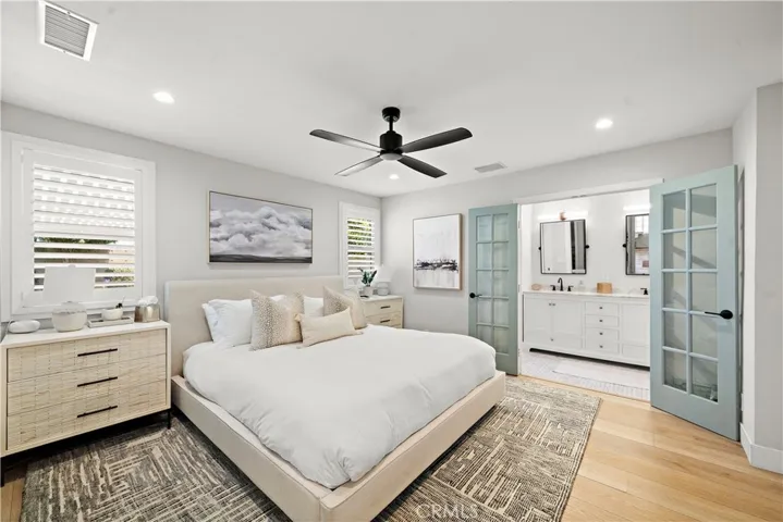 Primary suite: recessed lighting, French doors to ensuite bathroom, plantation shutters, luxury wide plank vinyl flooring