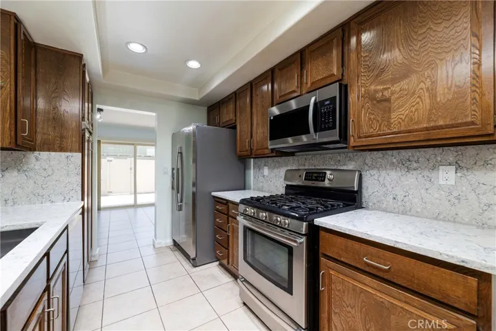 Kitchen - Quartz countertops, tile floors, recessed lighting and stainless appliances.