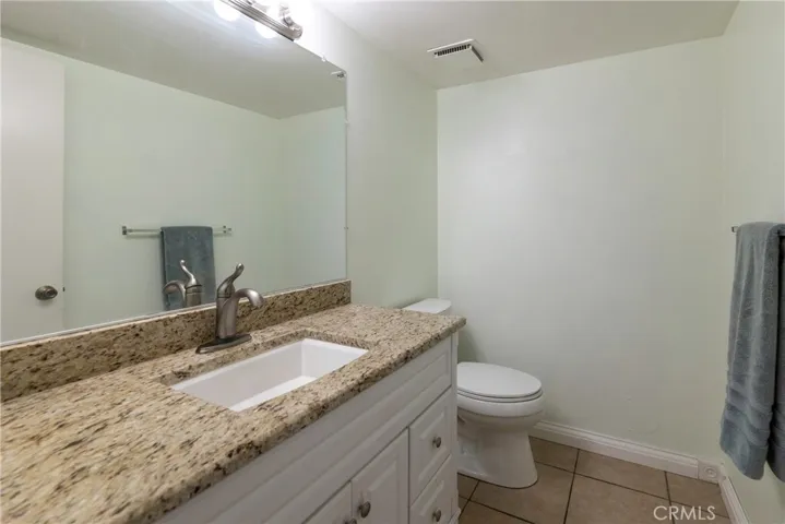 Downstairs bath with granite countertops and updated vanity.