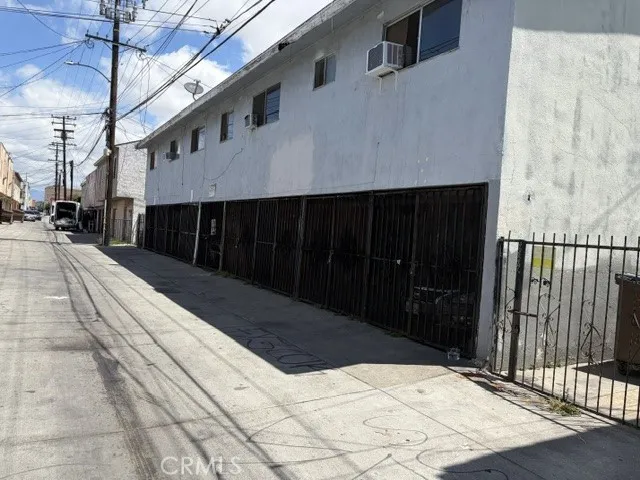 Alley view behind the building, showing rear entrance and garages.